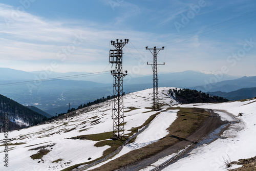 Residential area on snowy mountain summit, electricity poles