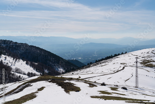 Stunning landscape from snowy mountain peak in sunny weather