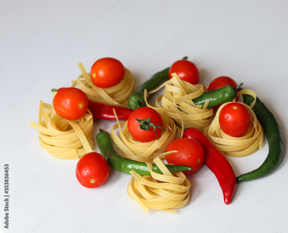tomatoes, chili peppers and pasta on a white background tomatoes, chili peppers and pasta on a white background