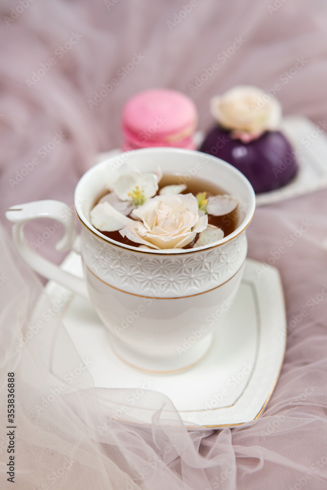 Composition on a light background: tea with flower petals, sweets and flowers. Still life with flowers and fruit tea Composition on a light background: tea with flower petals, sweets and flowers. Still life with flowers and fruit tea