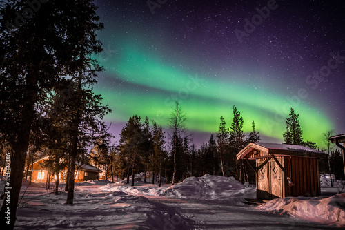 Northern lights shine over a winter landscape at night