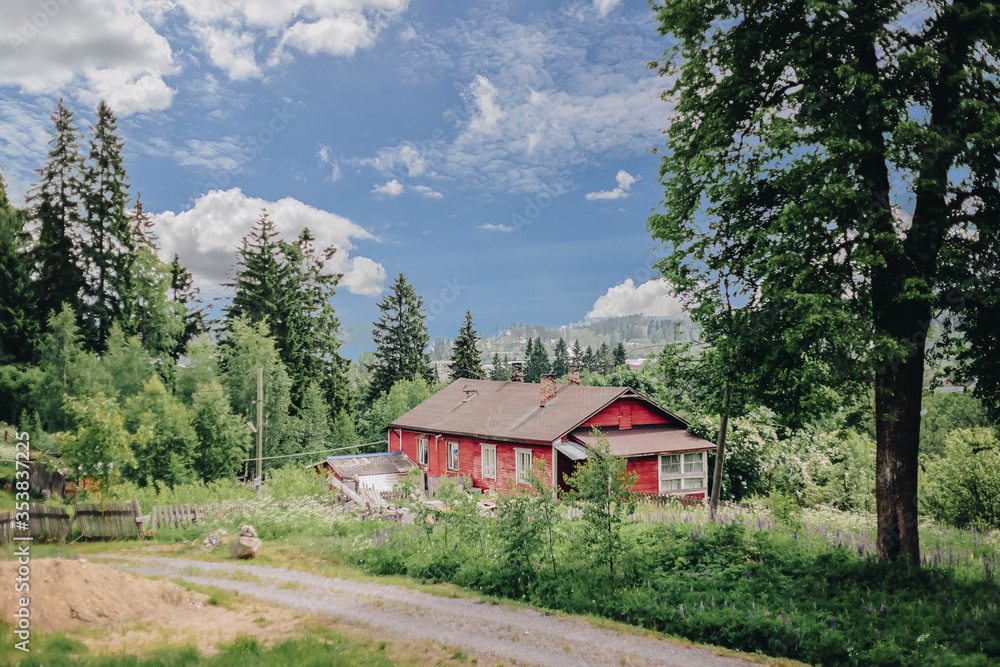 Rustic red house in the forest among the trees Rustic red house in the forest among the trees
