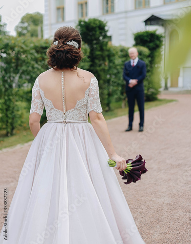 The bride goes to the groom with a bouquet of flowers