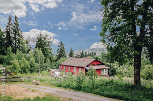 Rustic red house in the forest among the trees