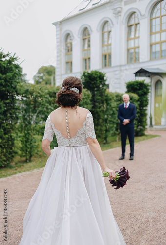 The bride goes to the groom with a bouquet of flowers