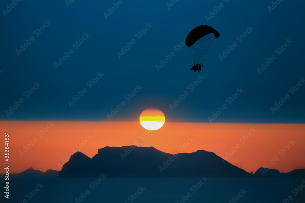 sunset in the mountains with paramotor  
silhouette