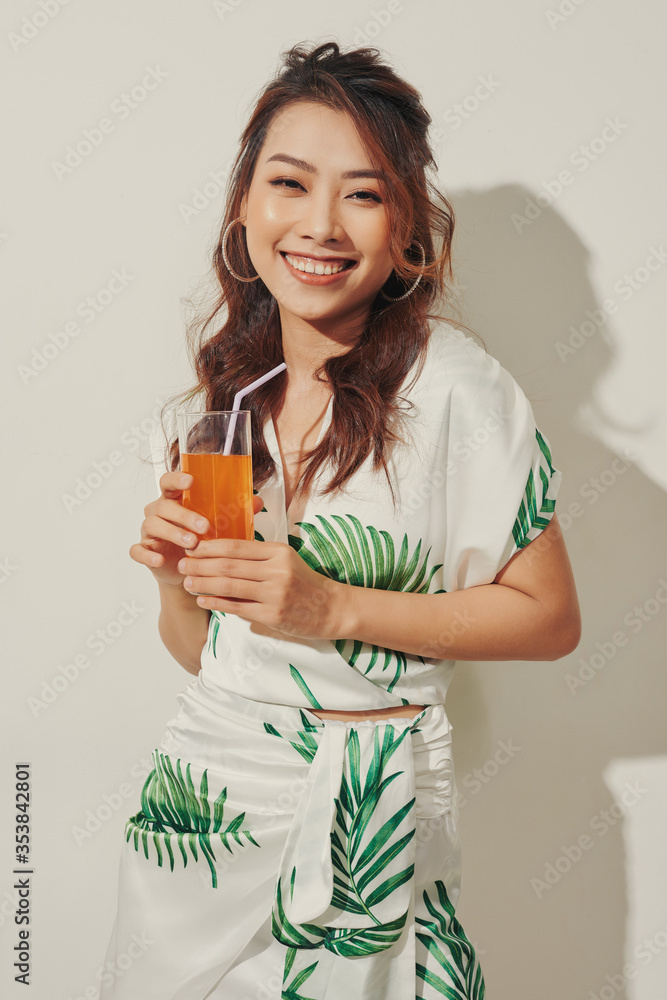 Happy Asian woman in summer casual clothes with a glass of fresh fruit juice drink Happy Asian woman in summer casual clothes with a glass of fresh fruit juice drink