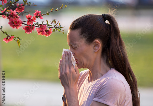 Woman blowing nose because of spring pollen allergy