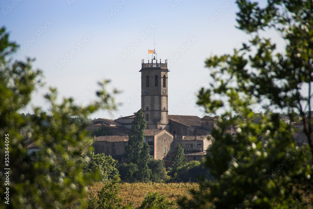 A small Spanish town appearing among the forest trees A small Spanish town appearing among the forest trees