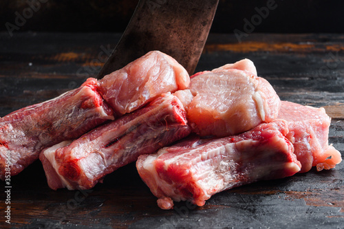 Fresh raw pork meat from organic farm over rustic wood and metal background side view close up.