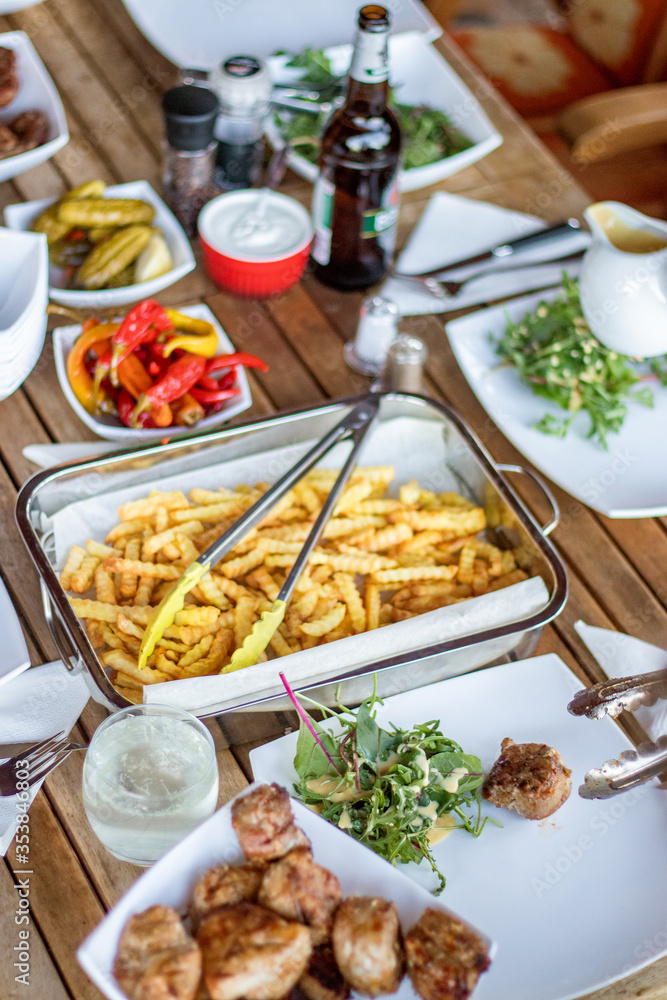 Table full of BBQ food and french fries with no people