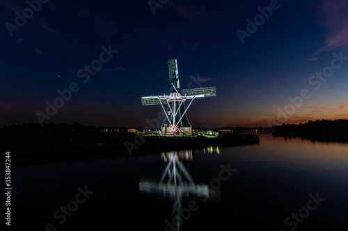 A traditional Dutch mill at sunset shot at a lake in Groningen 