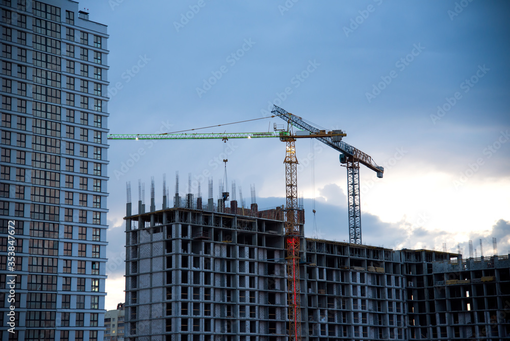 Tower cranes in action construction of a new multi-storey buildings in night. Multi-storey residential building is being constructed use of crane. Pouring of concrete in formwork Tower cranes in action construction of a new multi-storey buildings in night. Multi-storey residential building is being constructed use of crane. Pouring of concrete in formwork
