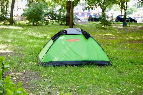 A litte green tent on a green lawn
