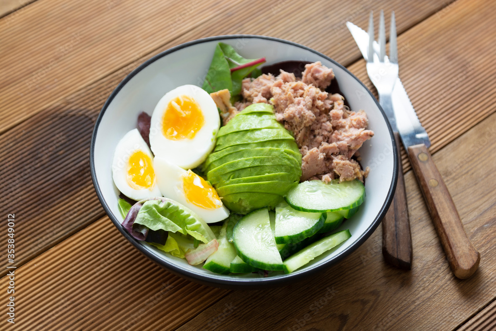 Healthy tuna and egg salad with avocado and fresh green salad mix leaves.