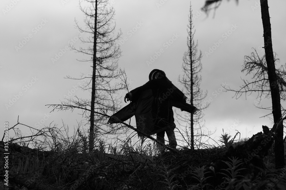 Human silhouette in the dry dead forest, black and white