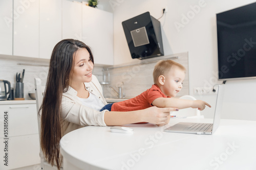 Woman and baby son having web video call with happy family on computer home. Communication people concept