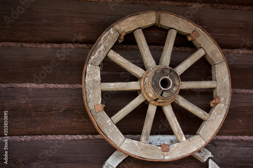 Wooden wheel on the wall © Artsiom