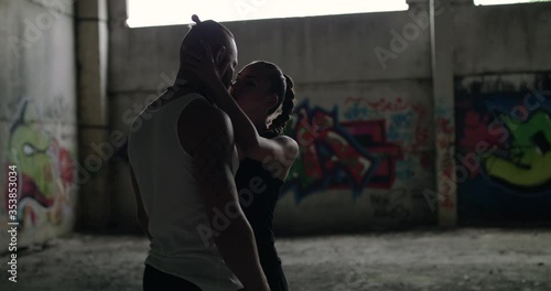 A passionate girl comes to her lover looks on, caresses his head and kisses him