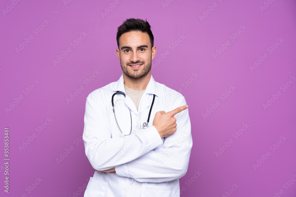 Young man wearing a doctor gown and pointing side Young man wearing a doctor gown and pointing side