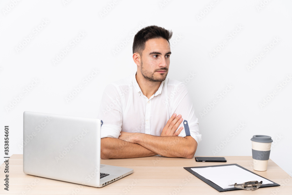 Young business man with a mobile phone in a workplace looking side Young business man with a mobile phone in a workplace looking side