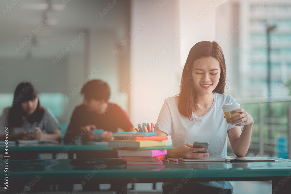 A young woman reading and writtening book with many books, happy education university concept. A young woman reading and writtening book with many books, happy education university concept.