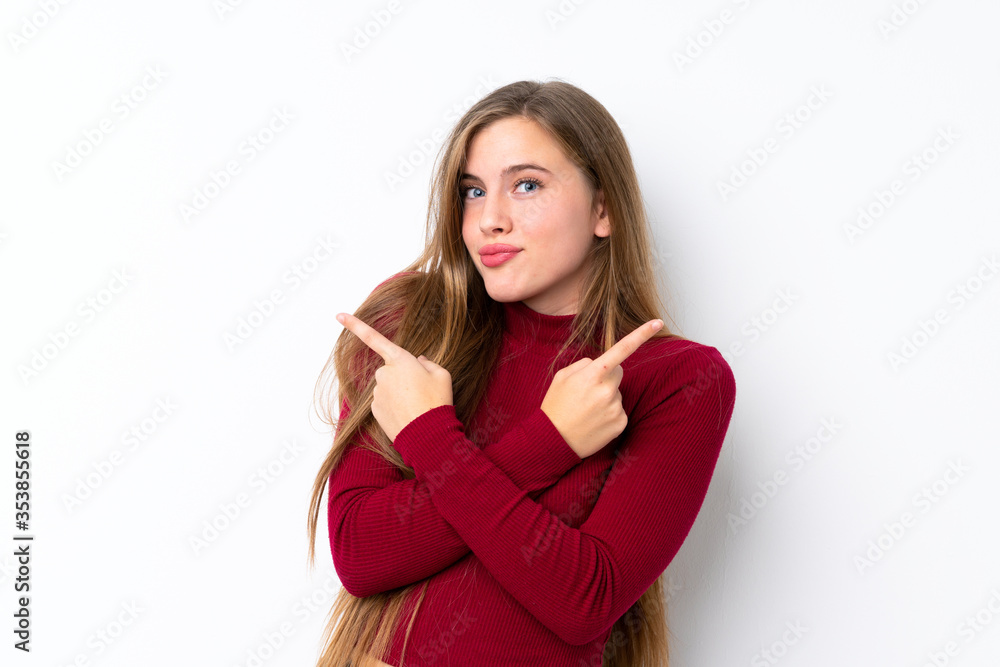 Teenager blonde girl over isolated white background pointing to the laterals having doubts Teenager blonde girl over isolated white background pointing to the laterals having doubts