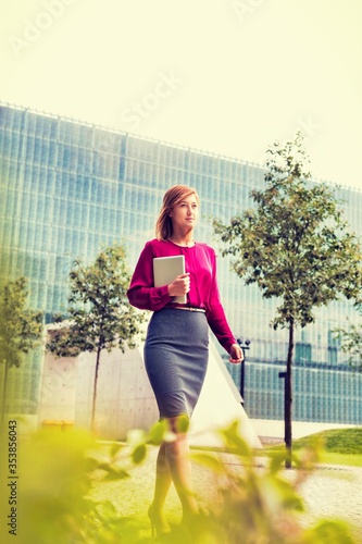 Fototapeta Naklejka Na Ścianę i Meble -  Portrait of young attractive businesswoman walking while holding digital tablet
