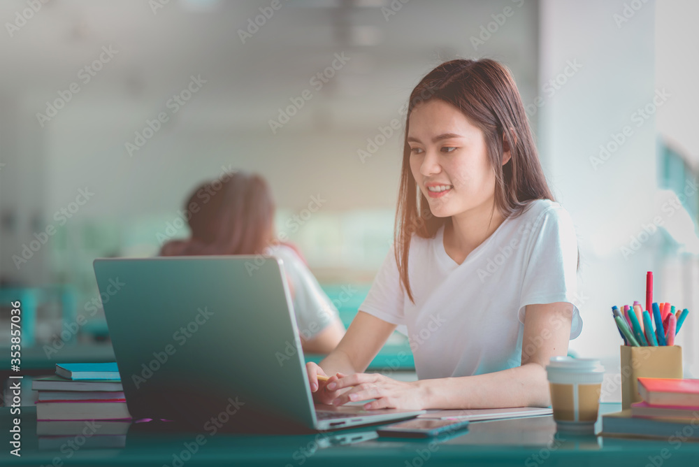 A young woman reading and writtening book with many books, happy education university concept. A young woman reading and writtening book with many books, happy education university concept.