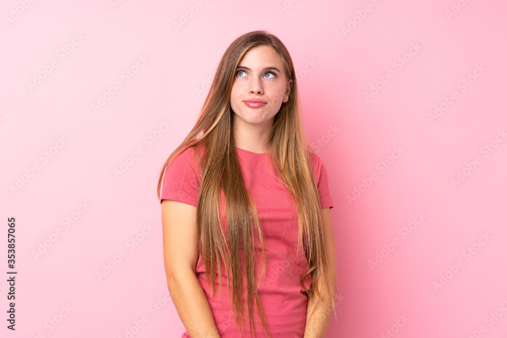 Teenager blonde girl over isolated pink background standing and looking to the side Teenager blonde girl over isolated pink background standing and looking to the side