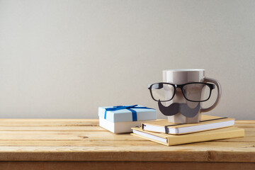 Happy Fathers day concept with coffee cup, mustache and gift box on wooden table
