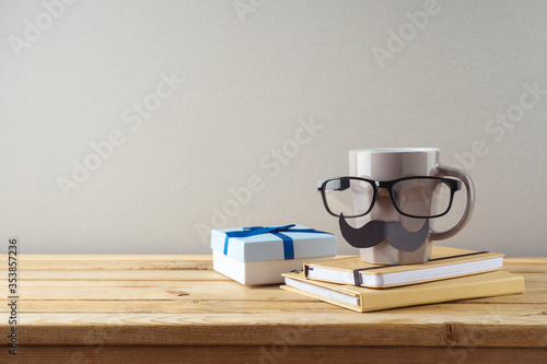 Happy Fathers day concept with coffee cup, mustache and gift box on wooden table
