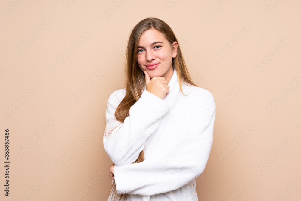 Teenager girl in a bathrobe over isolated background laughing Teenager girl in a bathrobe over isolated background laughing