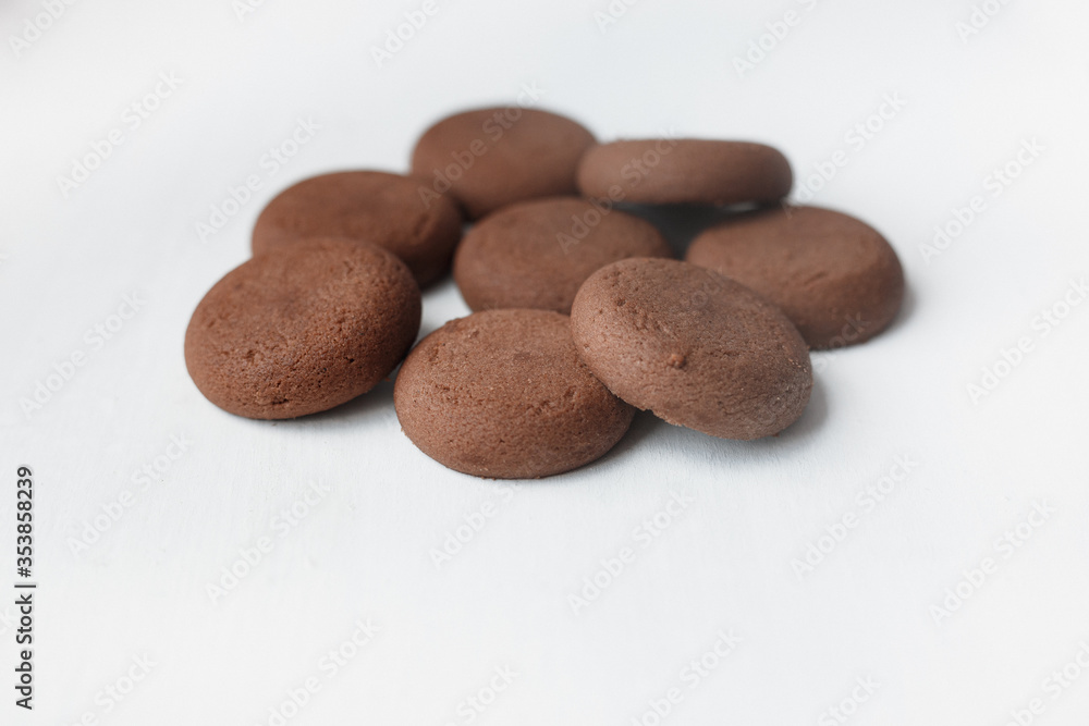 Several round brown chocolate cookies on white background top view Several round brown chocolate cookies on white background top view