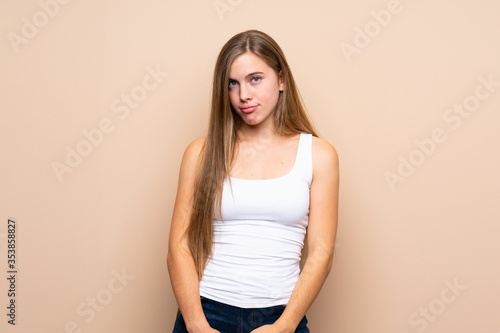 Teenager blonde girl over isolated background with sad and depressed expression