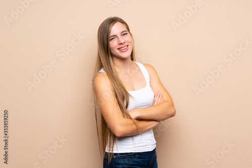Teenager blonde girl over isolated background with arms crossed and looking forward
