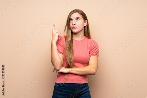 Teenager blonde girl over isolated background pointing with the index finger a great idea