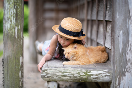 縁側でのんびり過ごす猫と少女