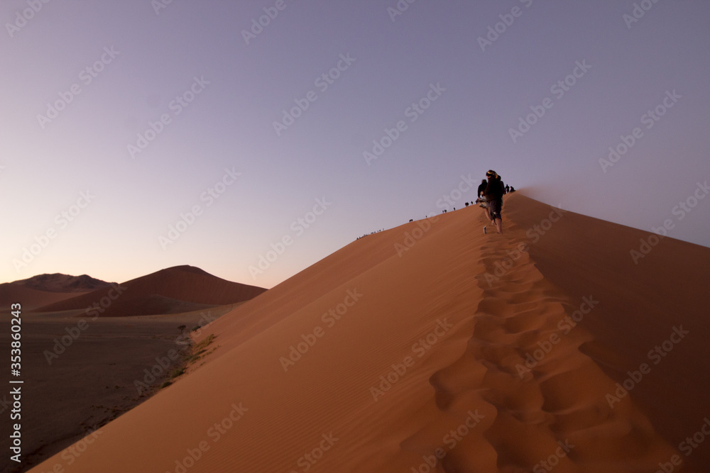 Climbing a giant sand dune at sunrise Climbing a giant sand dune at sunrise