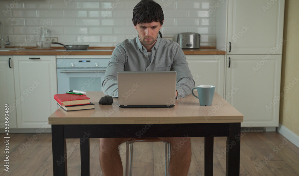 custom made wallpaper toronto digitalYoung man works at home on a laptop in a shirt without pants