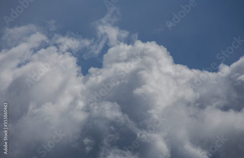 Fluffy clouds cover the summer blue sky