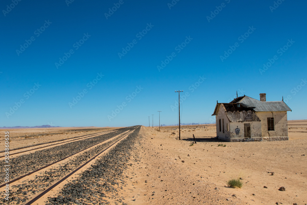 Railway track in desert with old train station