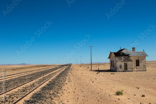 Obraz na płótnie Railway track in desert with old train station w salonie