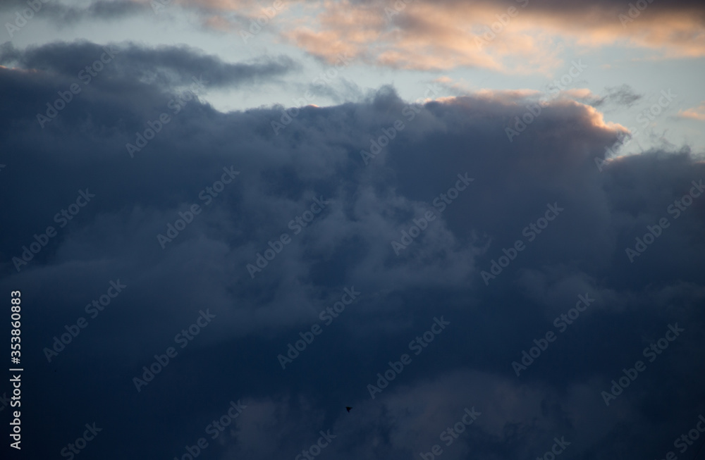 Fluffy clouds cover the summer blue sky