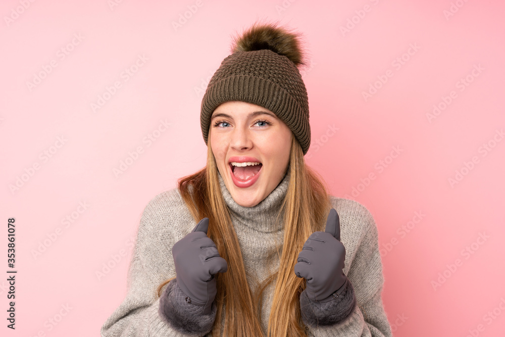 Young teenager girl with winter hat over isolated pink background celebrating a victory Young teenager girl with winter hat over isolated pink background celebrating a victory