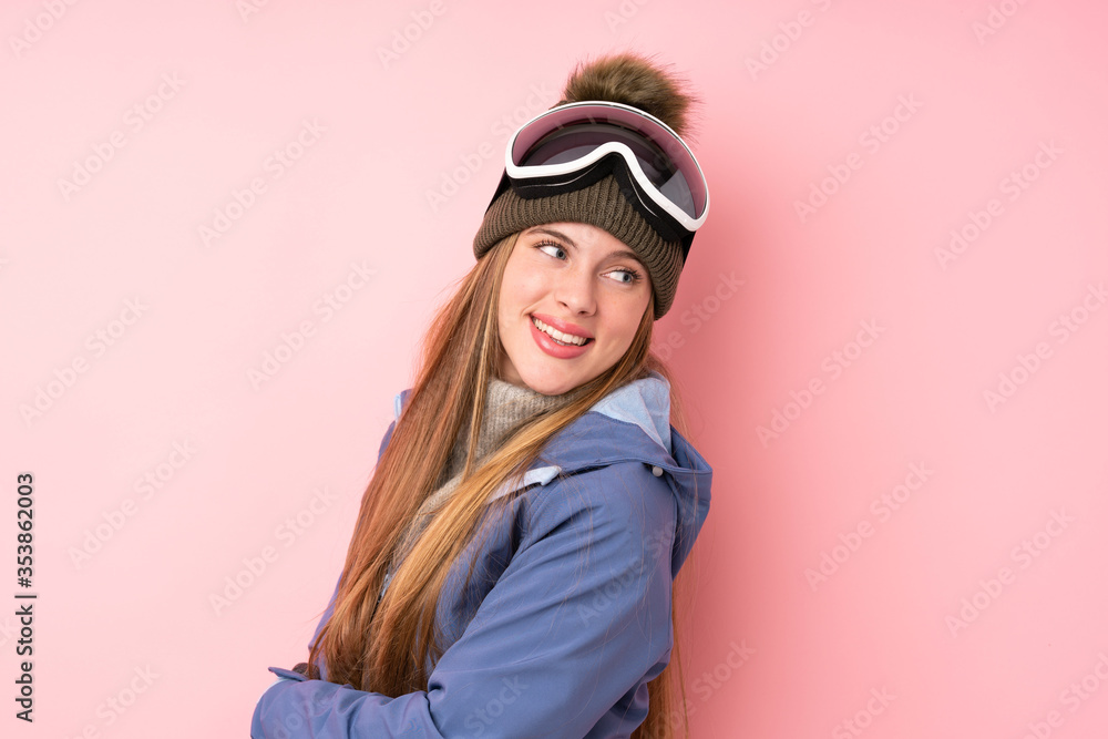 Skier teenager girl with snowboarding glasses over isolated pink background laughing Skier teenager girl with snowboarding glasses over isolated pink background laughing