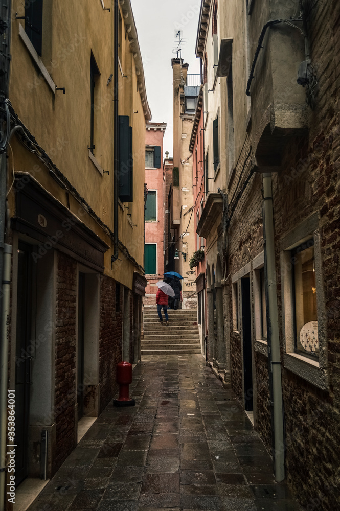 Old narrow street in Venice in the rain.