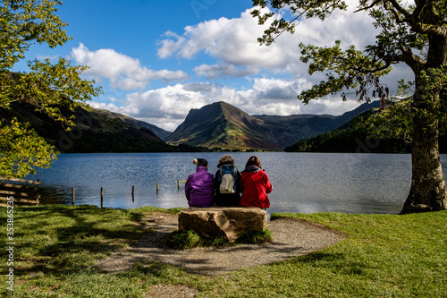 Quadro su tela female hikers relax on a bench , Buttermere, Lake District