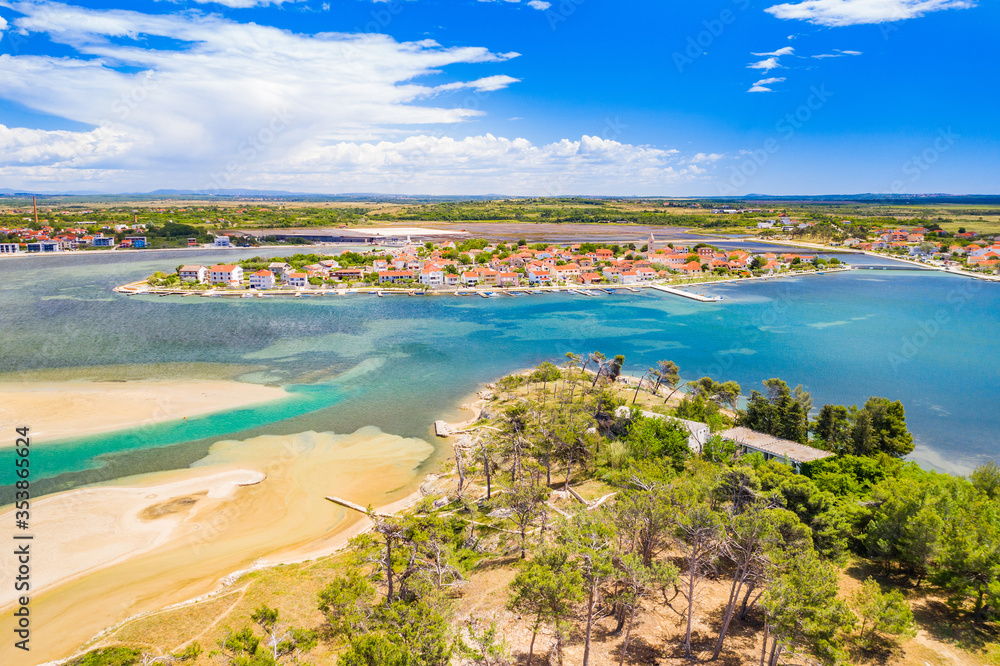 Aerial view of town of Nin and lagoon in Dalmatia, Croatia. Coastline and turquoise water and blue sky with clouds.
