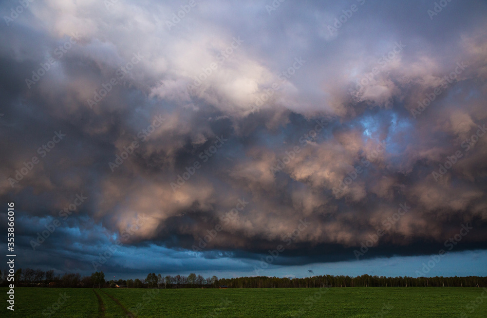 Landscape with majestic colorful dramatic red sky with fluffy clouds at sunset before before a thunderstorm and rain with the spacious field. Landscape with majestic colorful dramatic red sky with fluffy clouds at sunset before before a thunderstorm and rain with the spacious field.